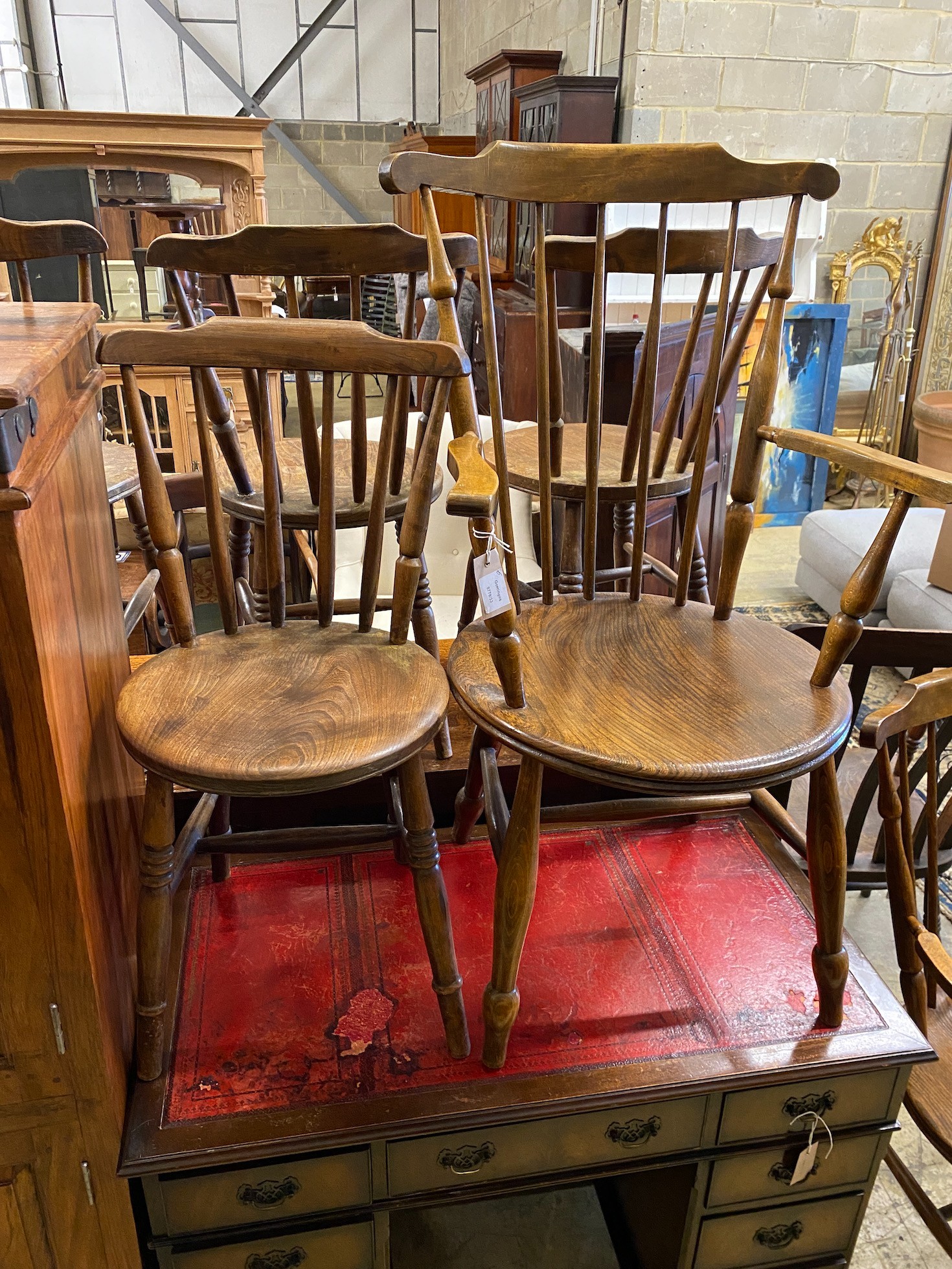 An early 20th century harlequin set of six Windsor elm and beech dining chairs, two with arms